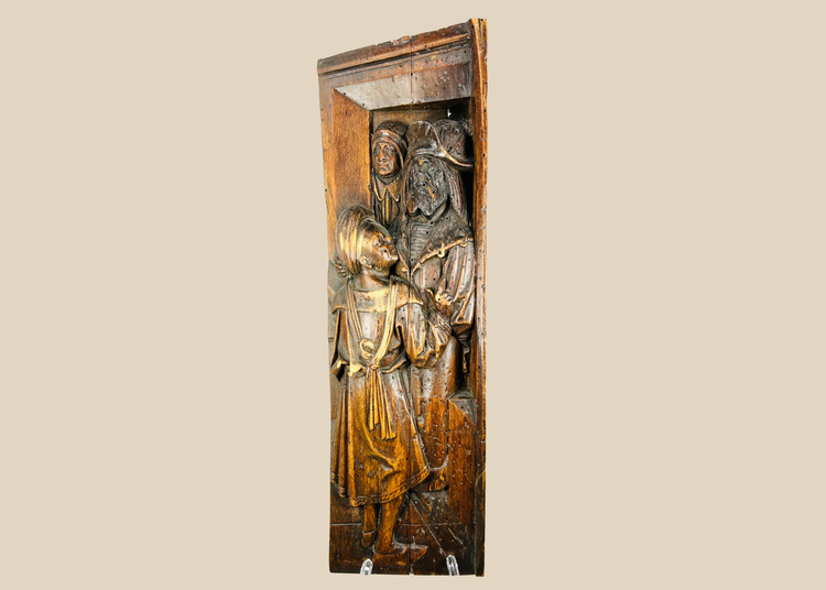 Front-facing view of antique Tudor carved oak panel with two robed figures in high relief.