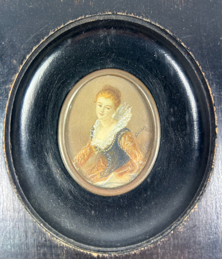 Mid–late 19th-century Continental European miniature portrait of a young woman in historicizing costume with deep blue bodice, amber sleeves, and lace ruff, watercolor/gouache on thin wafer, signed lower right, in ebonized wood frame with oval brass bezel, after Fragonard, circa 1860–1890.
