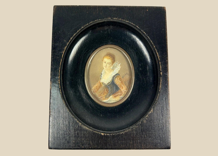 Mid–late 19th-century Continental European miniature portrait of a young woman in historicizing costume with deep blue bodice, amber sleeves, and lace ruff, watercolor/gouache on thin wafer, signed lower right, in ebonized wood frame with oval brass bezel, after Fragonard, circa 1860–1890.