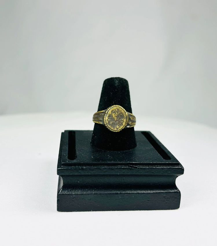 Ancient Mediterranean bronze ring with gold-gilded floral decoration, symbolic of renewal and prosperity