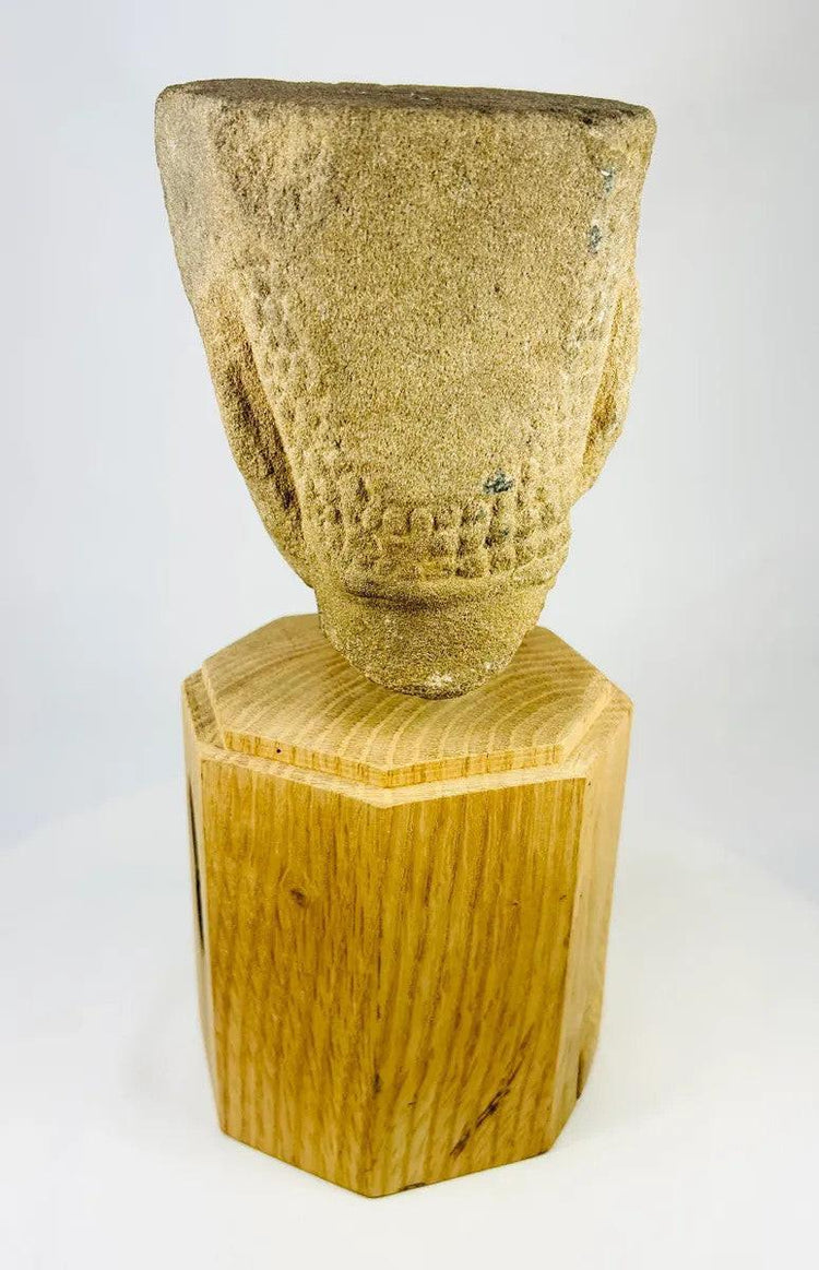 Rear angled view of Khmer Sandstone Buddha Head Fragment from 12th-Century Angkor Period Cambodia, showing detailed hair texture and sandstone weathering, mounted on wooden base – Relic and Rarity.