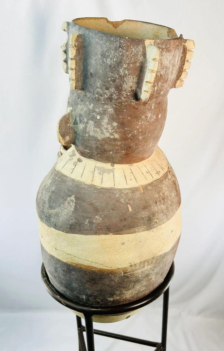 Ancient Peruvian effigy urn featuring detailed headdress and geometric decoration