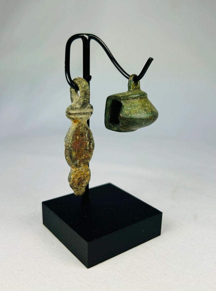 Side view of a Roman bronze pendant showing elongated stylized form