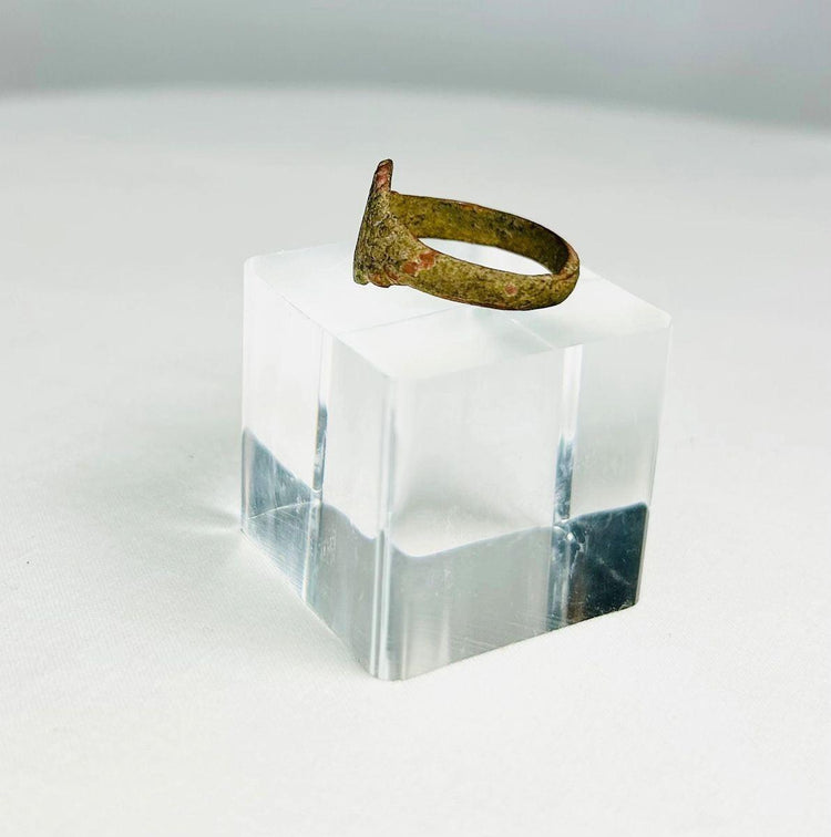 Close-up of an ancient bronze ring showing aged patina and simple bezel design from antiquity