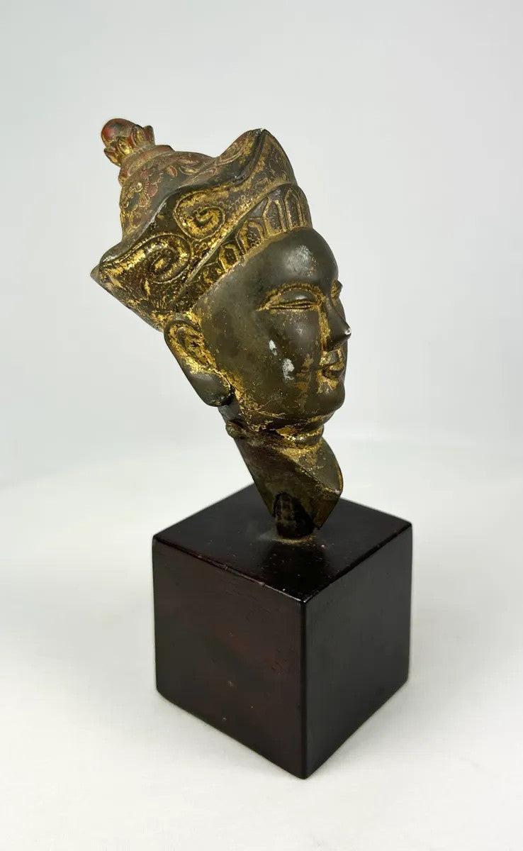 Antique Himalayan gilt bronze Buddha head with polychrome traces and ornate headdress, fragment from a larger statue, dating to the 18th–19th century.