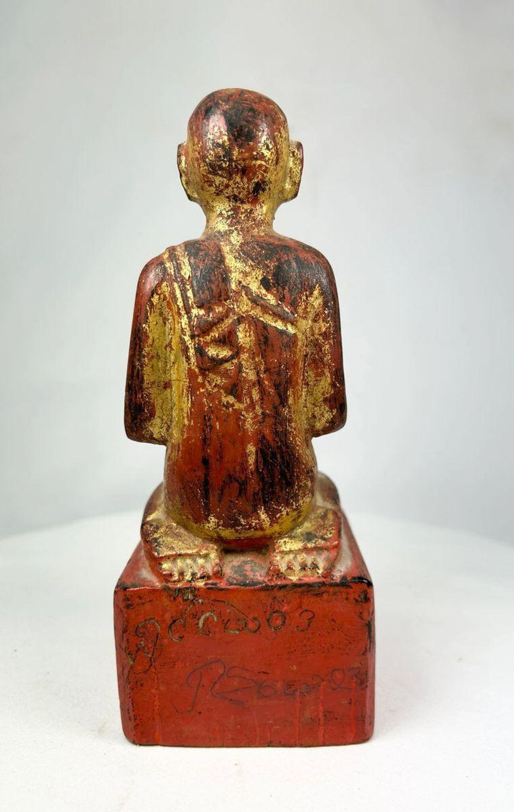 Close-up of the statue’s pedestal base with traces of red lacquer and traditional Burmese craftsmanship.