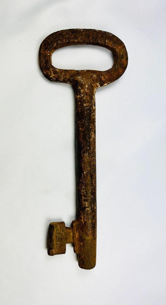 Side view of large 18th-century iron skeleton key with thick shaft and hand-forged ward, authentic European artifact from Relic and Rarity.