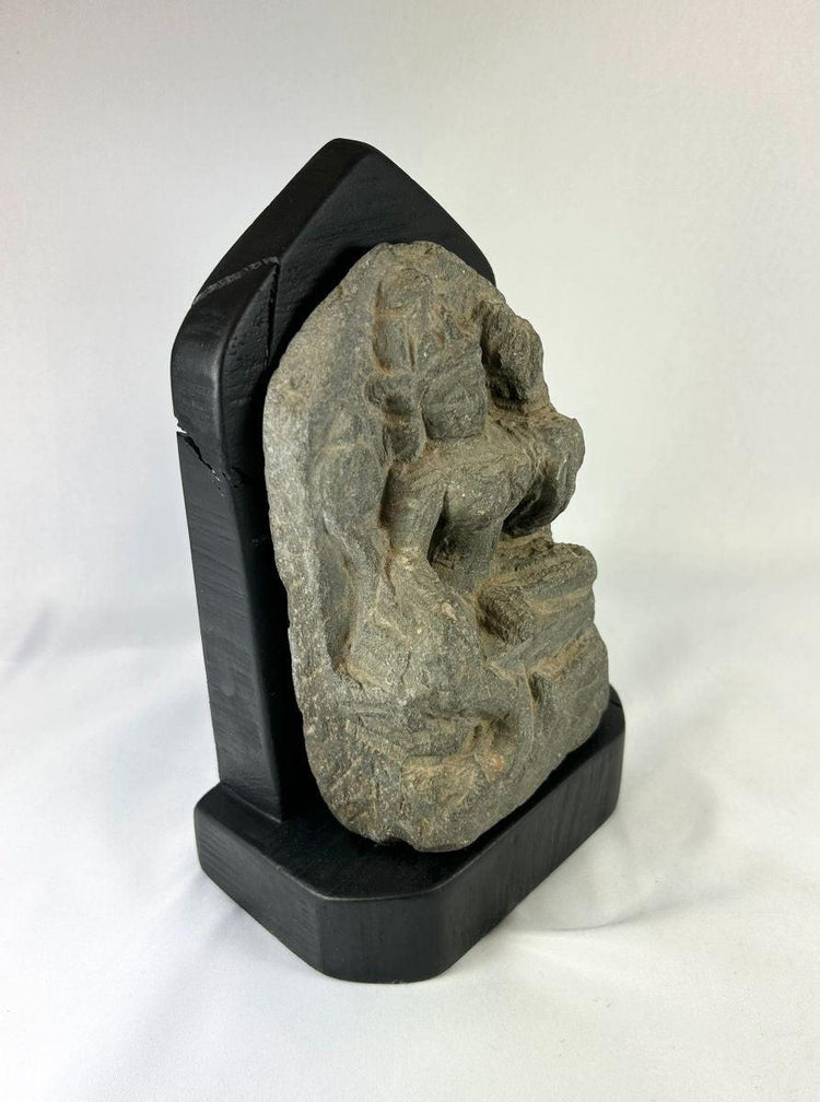 Side view of a medieval Tibetan stone stele showing carved contours and weathered surface