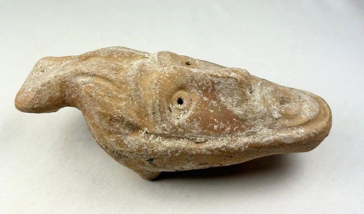 Byzantine terracotta lamp featuring human face and aged surface encrustations