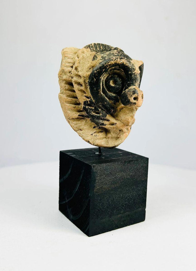 Pre-Columbian Mesoamerican mask with traces of black pigment and stylized animal face