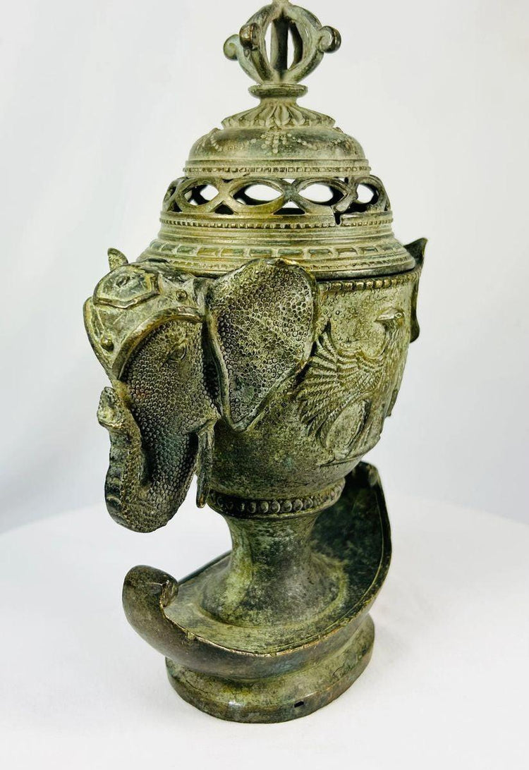 Qing Dynasty bronze censer with elephant-head handles, phoenix motifs, and vajra finial on a white background.