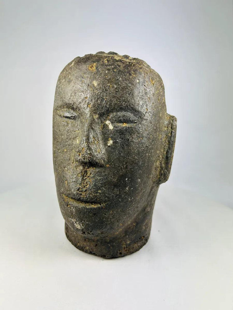 Polynesian volcanic stone sculpture showing stylized facial features and aged patina.