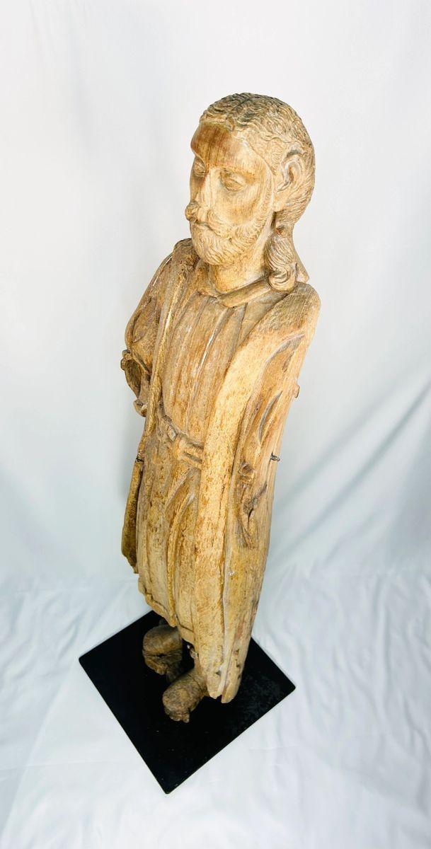 Antique European wood sculpture of saint, devotional church figure, medieval–Renaissance period, worn surface, detailed facial carving, mounted on custom iron stand for display.