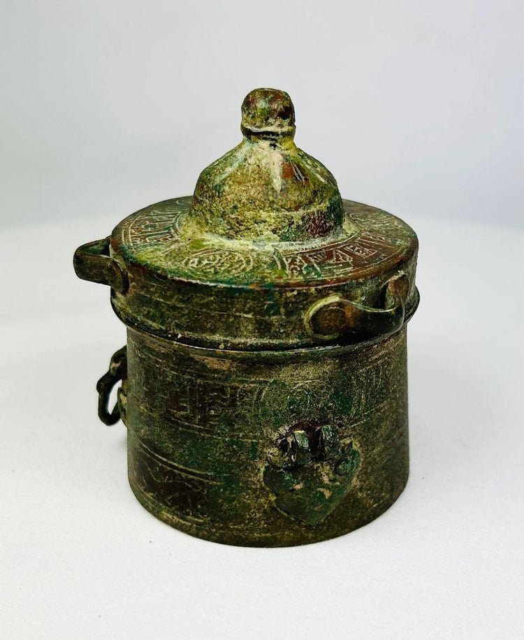 Side view of a medieval Islamic bronze inkwell from Khorassan showing continuous engraved motifs