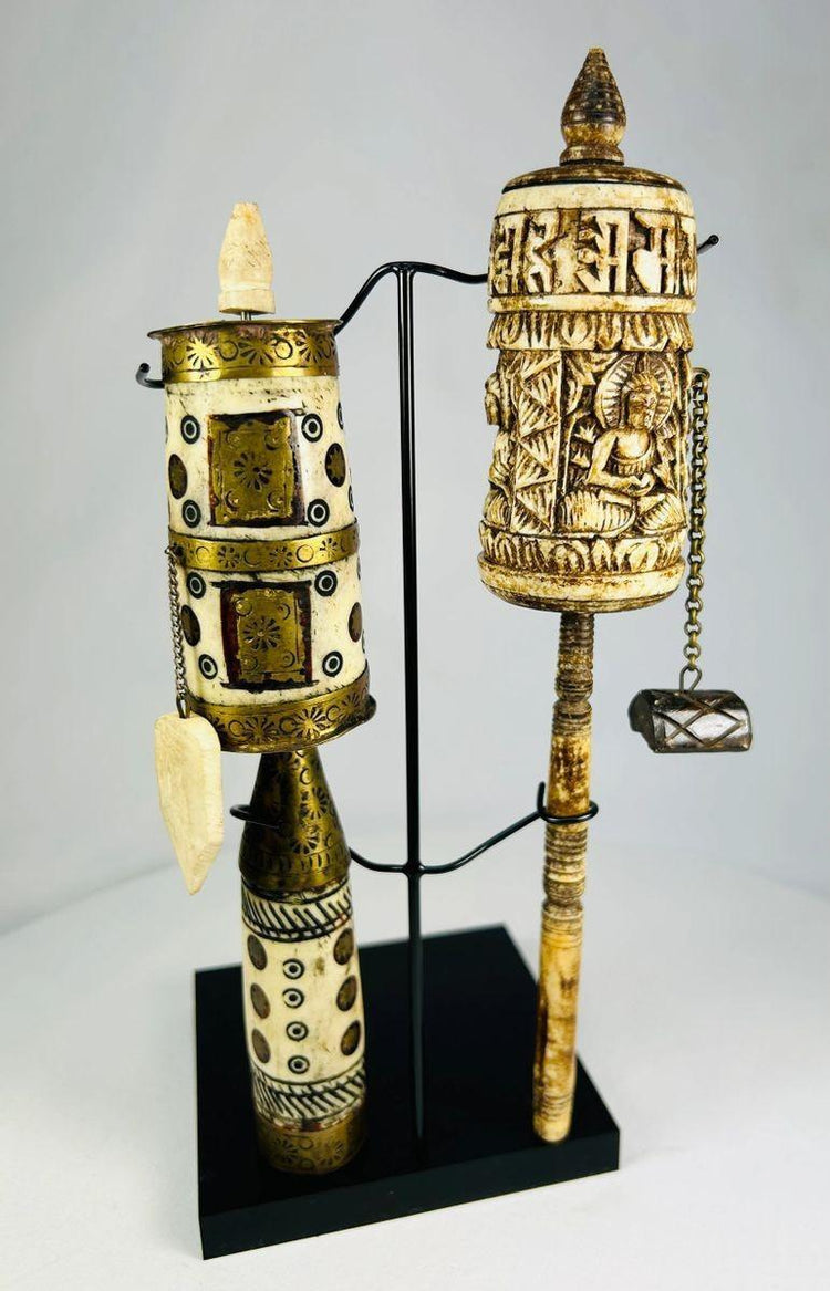 Tibetan prayer wheel pair with engraved mantras and Buddha imagery