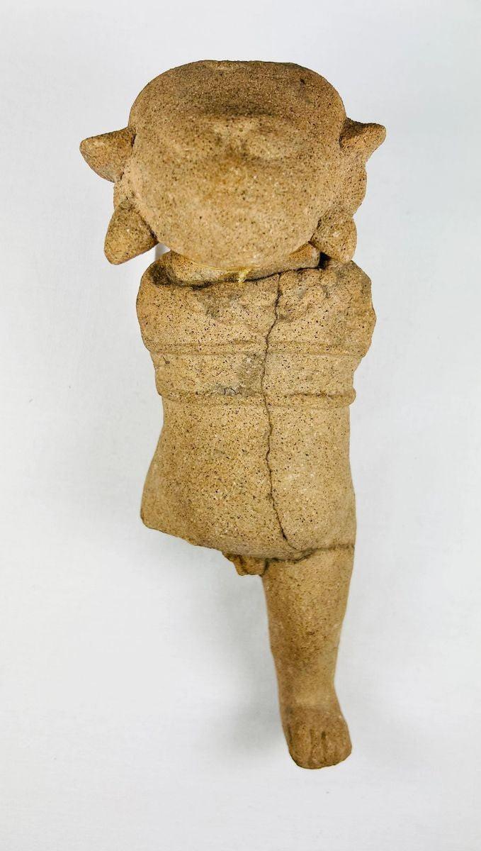 Ancient Mesoamerican terracotta figurine with stylized facial features and ritual form
