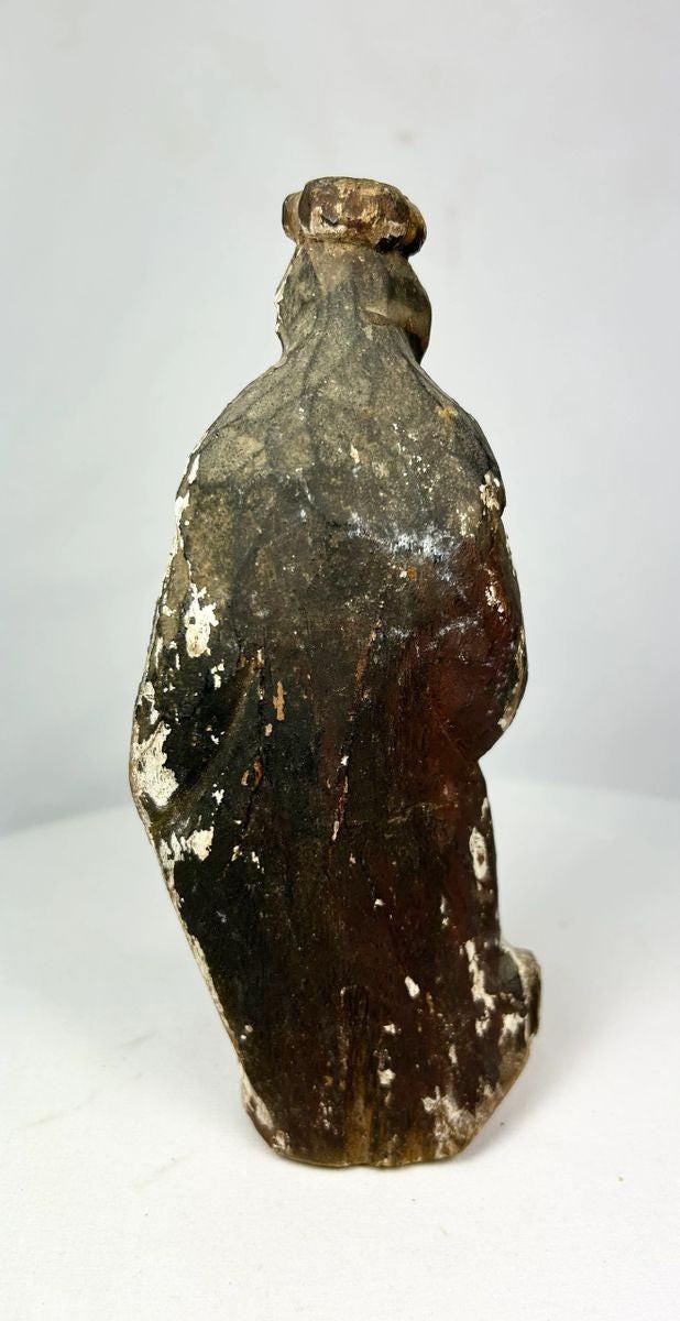 Spanish Colonial hand-carved santo statue on pedestal, centuries-old devotional object with gilt and polychrome remnants, rich patina and ritual wear.