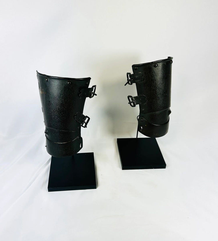 Pair of medieval Continental armour vambraces from the 15th–16th century, European steel forearm guards with riveted hinges displayed on black museum stands, Relic and Rarity.