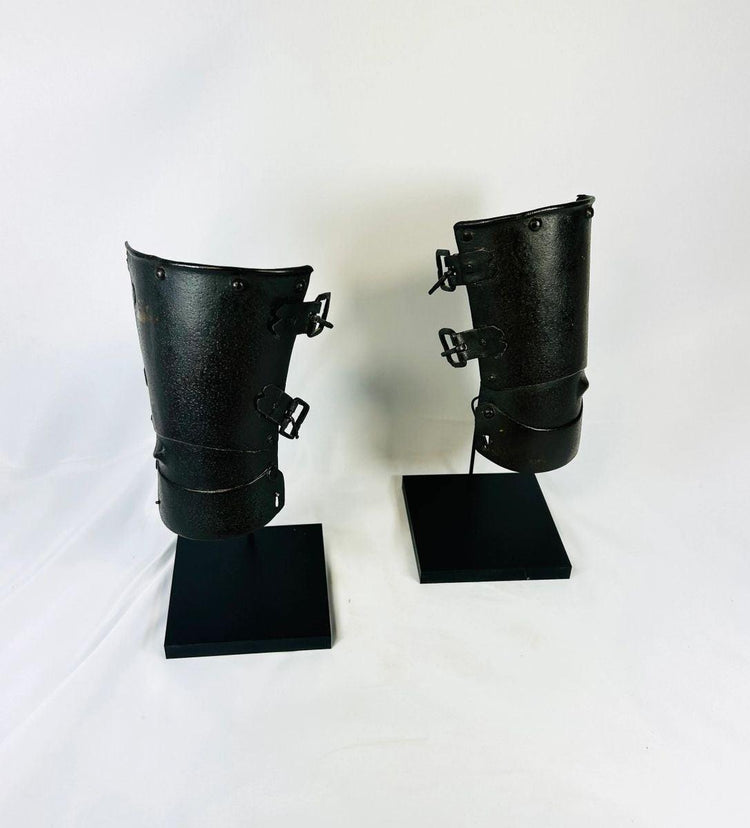 Pair of medieval Continental armour vambraces from the 15th–16th century, European steel forearm guards with riveted hinges displayed on black museum stands, Relic and Rarity.