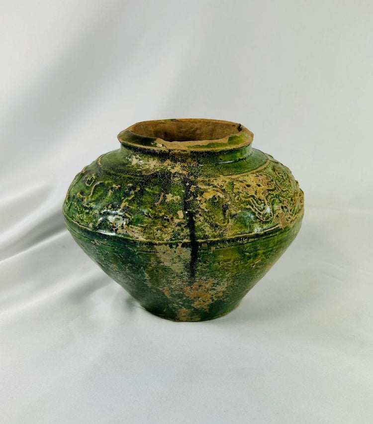 Detail shot of molded figures on Han Dynasty pottery jar showing craftsmanship and age.