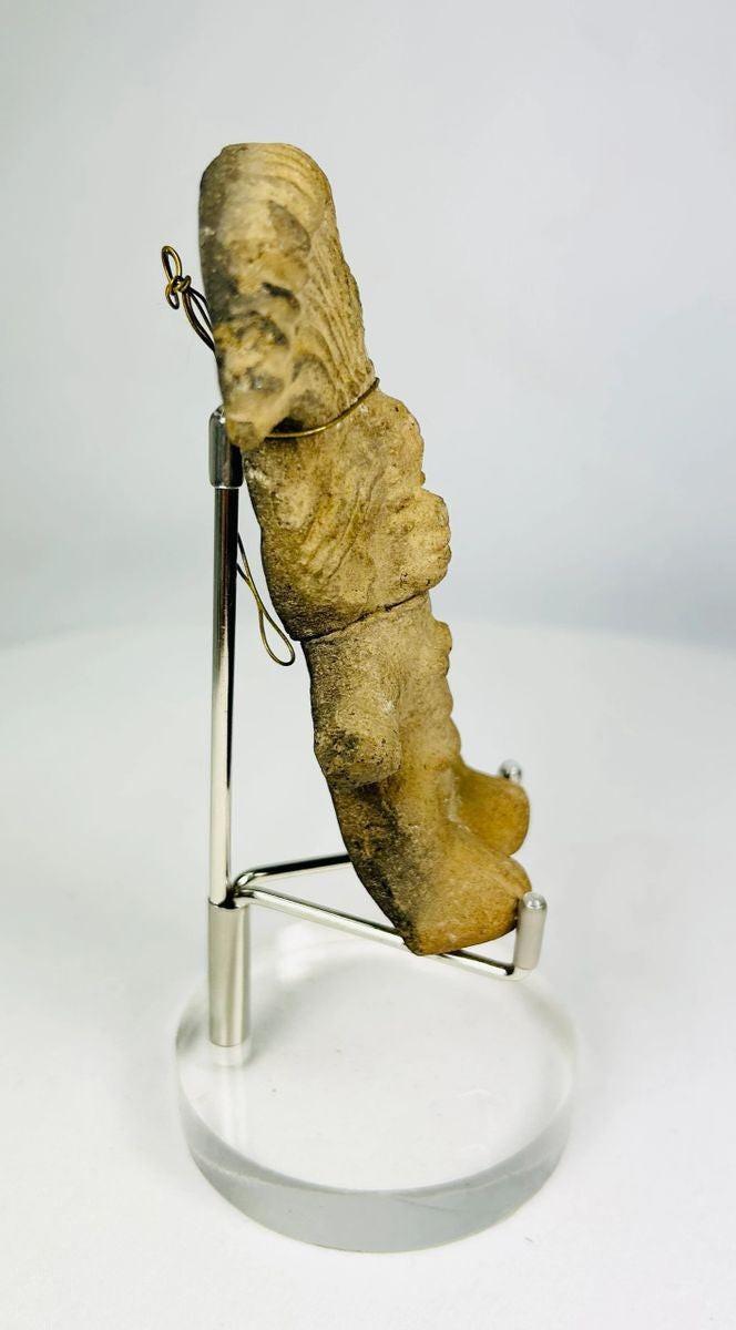 Angled view of a Pre-Columbian terracotta figurine displaying surface texture and patina