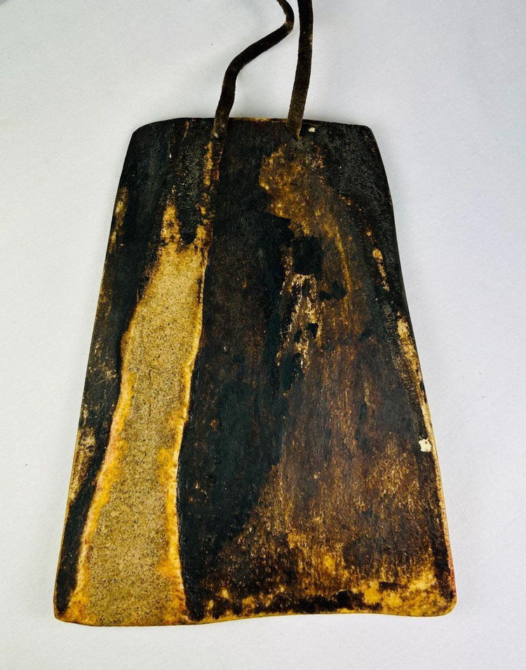 Reverse side of an antique Tibetan portable amulet showing aged bone surface and suspension loop