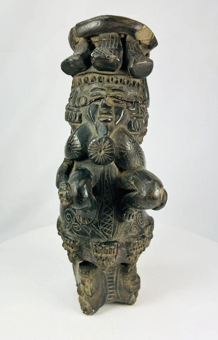 Stylized seated ceramic figure with intricate geometric decoration