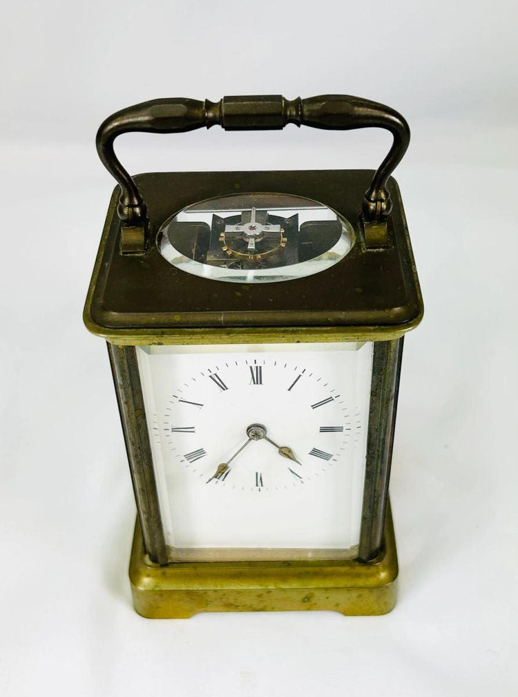 Late 19th-century French brass carriage clock featuring enamel dial and Roman numerals.