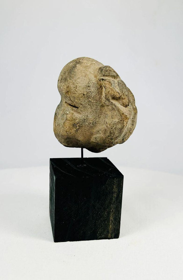 Pre-Columbian Mesoamerican stone mask showing stylized human face