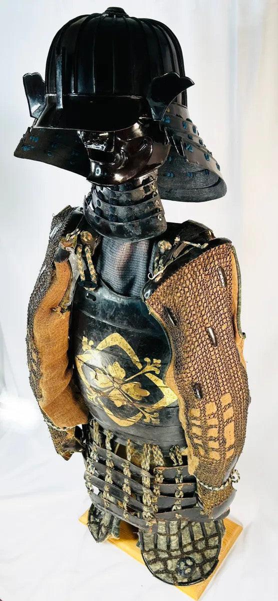 Left side profile of Muromachi Samurai armor (1333–1573) showing lacquered plates, silk lacing, and gold mon crest on cuirass.