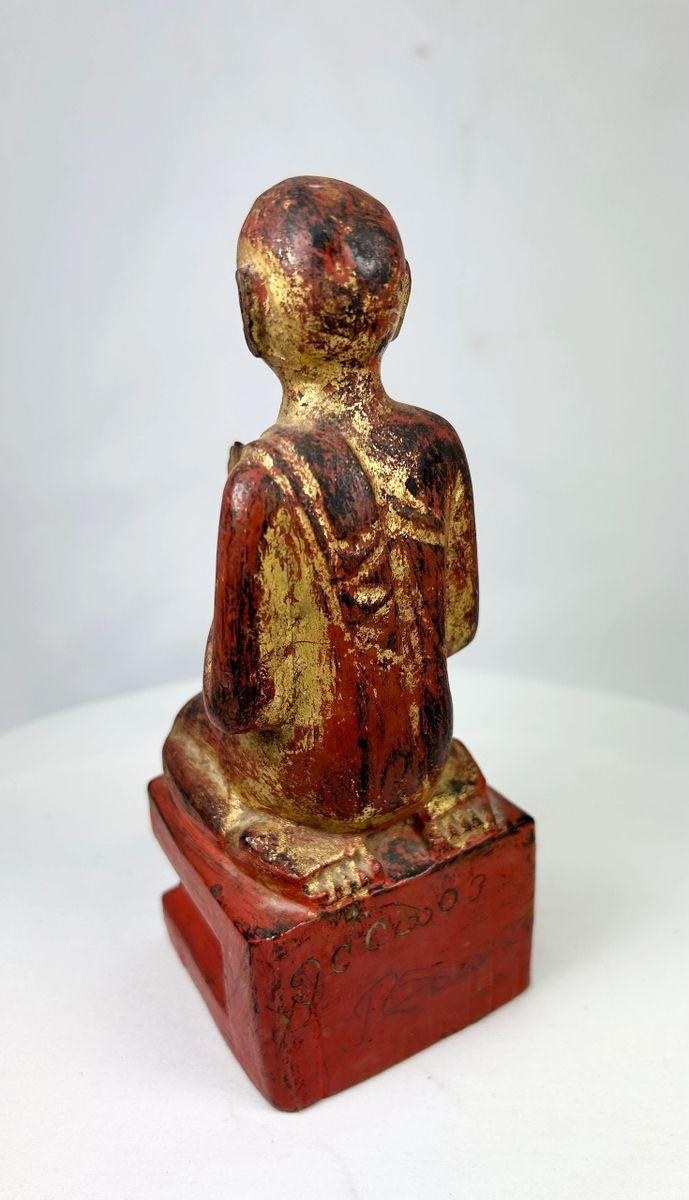 Rear view of antique Burmese gilt-lacquered monk statue with textured lacquer and carved pedestal base.