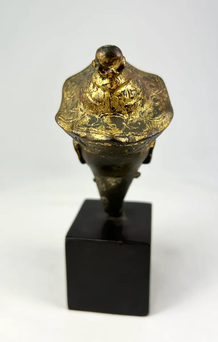 Antique Tibetan Buddhist bronze Buddha head with traces of original gilding and polychrome, crowned with incised floral decoration, dating to the 18th–19th century.