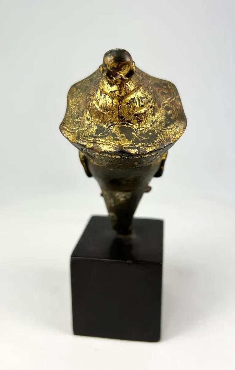 Antique Tibetan Buddhist bronze Buddha head with traces of original gilding and polychrome, crowned with incised floral decoration, dating to the 18th–19th century.
