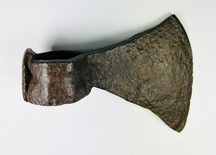 19th-century forged iron axe head from early American settlers shown with weathered patina and wide blade.