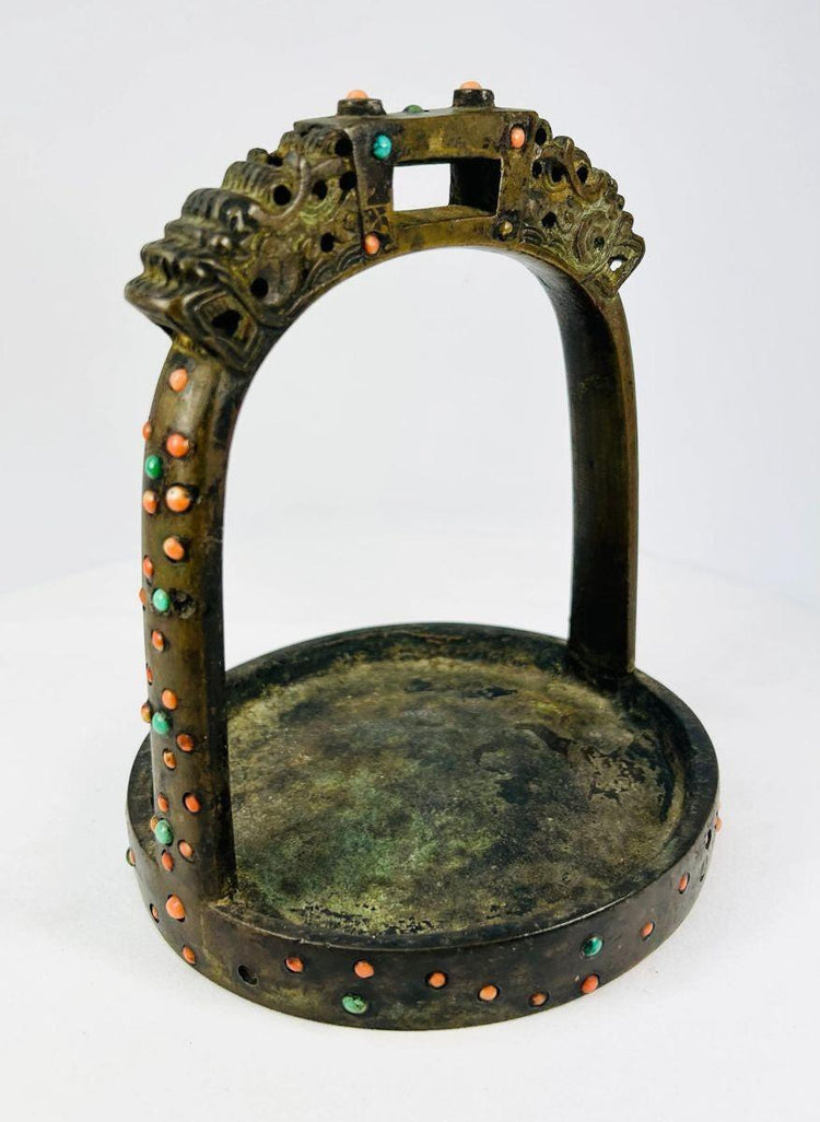 Rotated view emphasizing arch shape, stone inlays, and casting marks on antique stirrup.