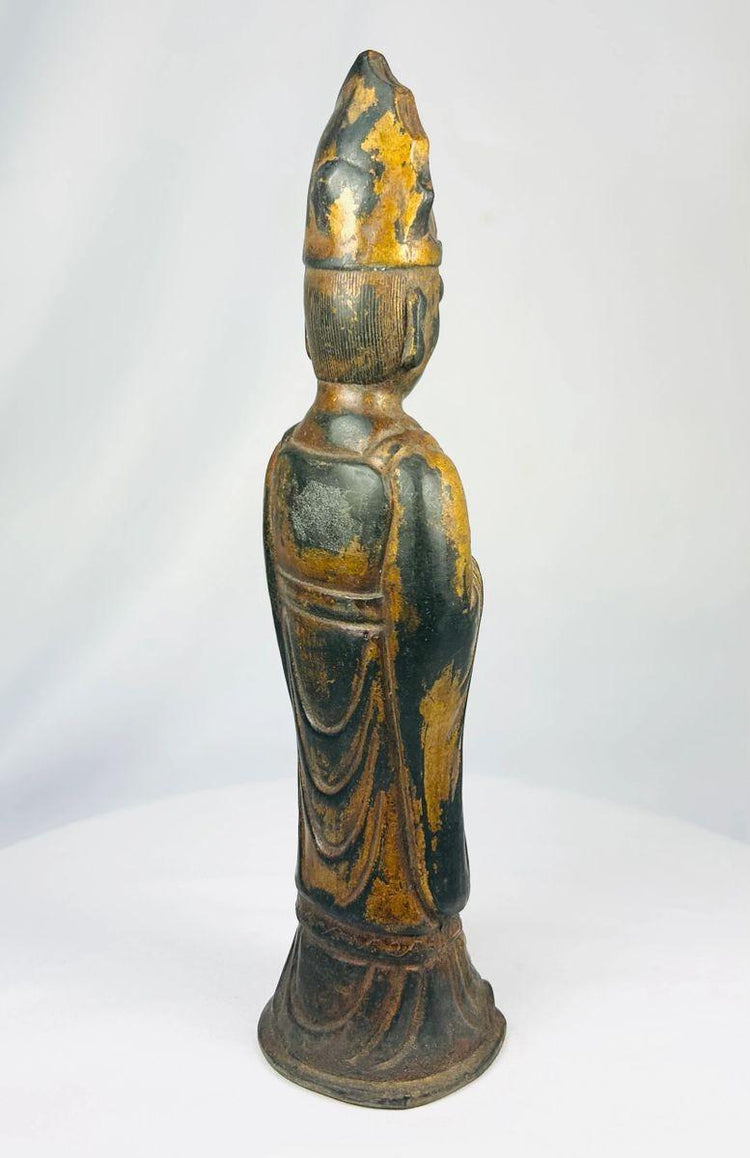 Rear view of an antique Tibetan Lama gilt bronze figure displaying robe folds
