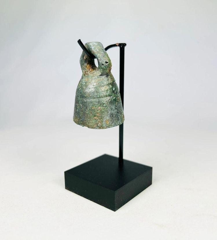 Ancient Roman cast bronze bell from 1st–4th century CE with looped suspension handle and aged patina.
