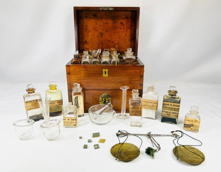 Antique Victorian apothecary box with glass bottles, brass fittings, balance scales, and chemist’s tools — 19th-century mahogany medical kit from England.