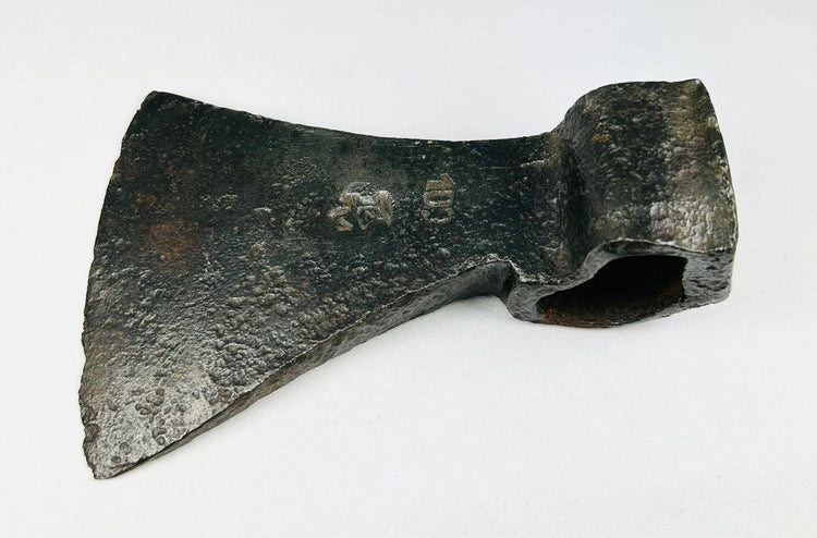 Antique European iron axe head showing maker’s mark and aged surface patina