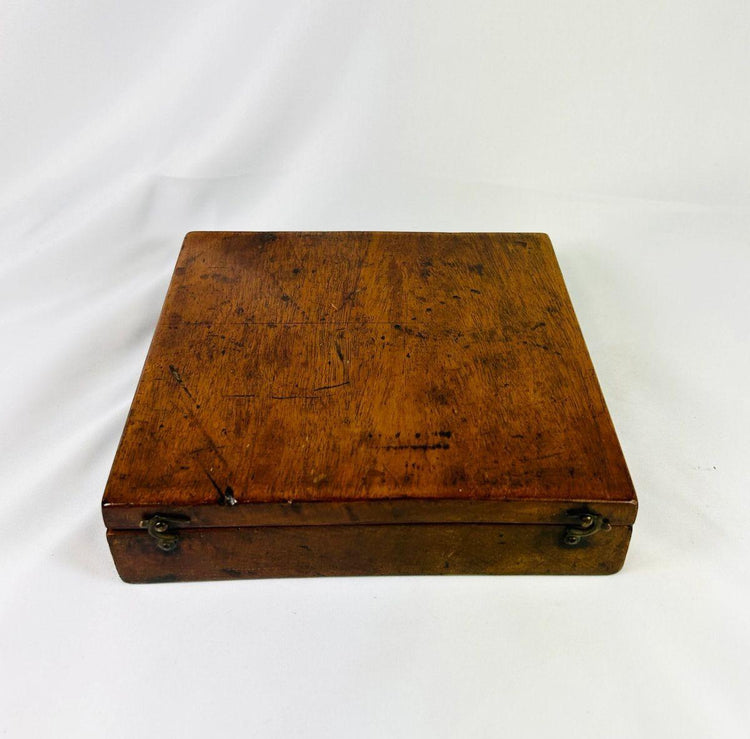 Closed walnut case of 19th century alidade surveying compass showing exterior wood grain