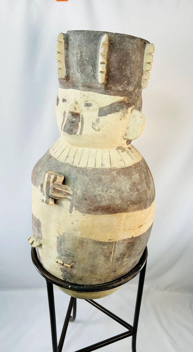 Large Chancay terracotta effigy urn from ancient Peru (1000–1400 CE), Pre-Columbian pottery depicting a stylized human figure with geometric painted motifs and ceremonial headdress, displayed on metal stand at Relic and Rarity.