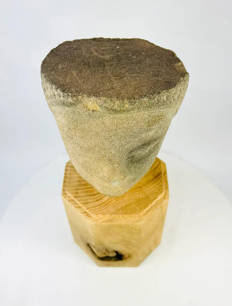 Top-down view of Khmer Sandstone Buddha Head Fragment from 12th-Century Angkor Period Cambodia, showing weathered crown surface and natural sandstone texture on wooden display base – Relic and Rarity.