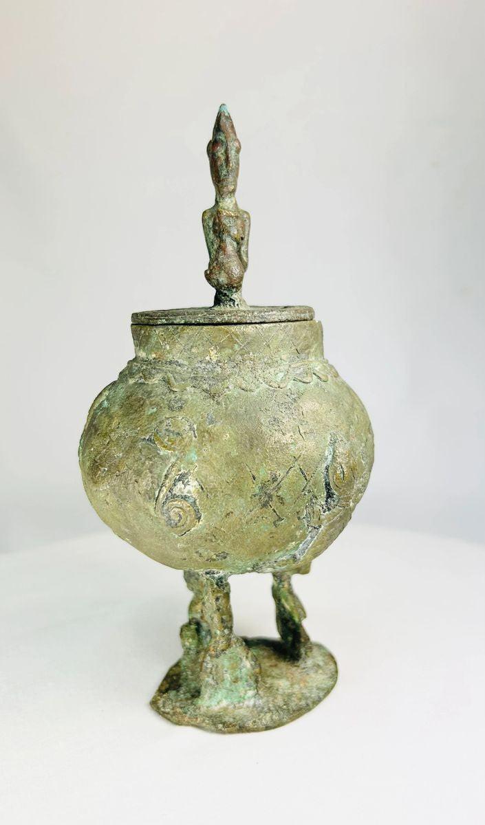 Antique Dogon bronze container with symbolic human-shaped lid and crafted legs.