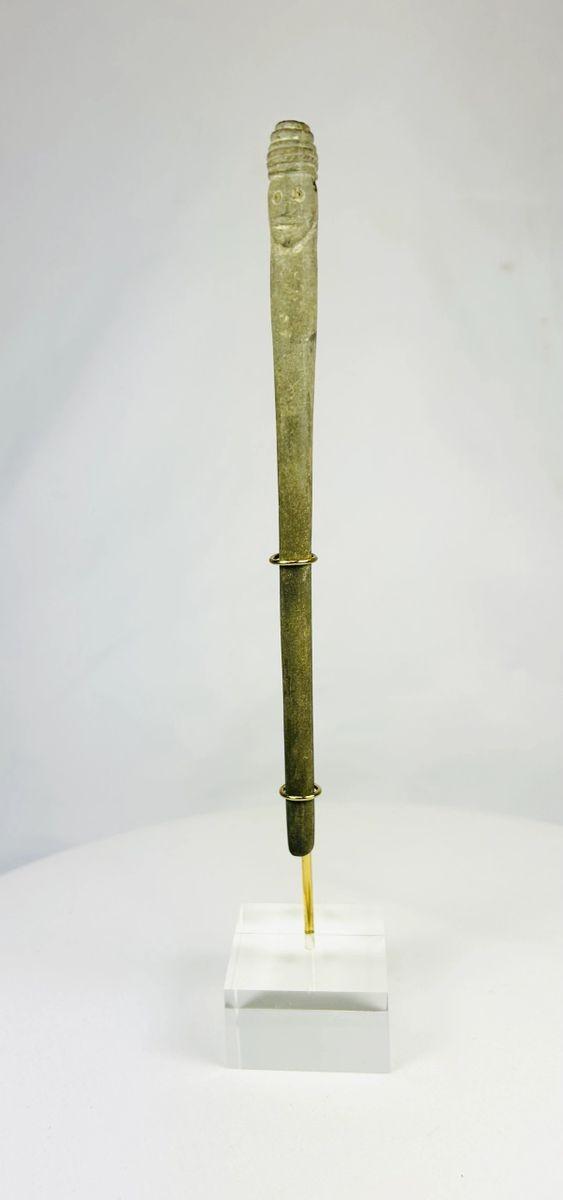 2nd millennium BCE Bactrian stone idol with carved human faces shown upright on a modern museum-style stand.