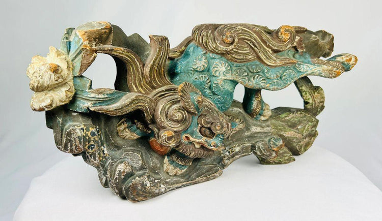 Close-up of a Qing Dynasty Qilin carving showing aged wood grain and polychrome remnants