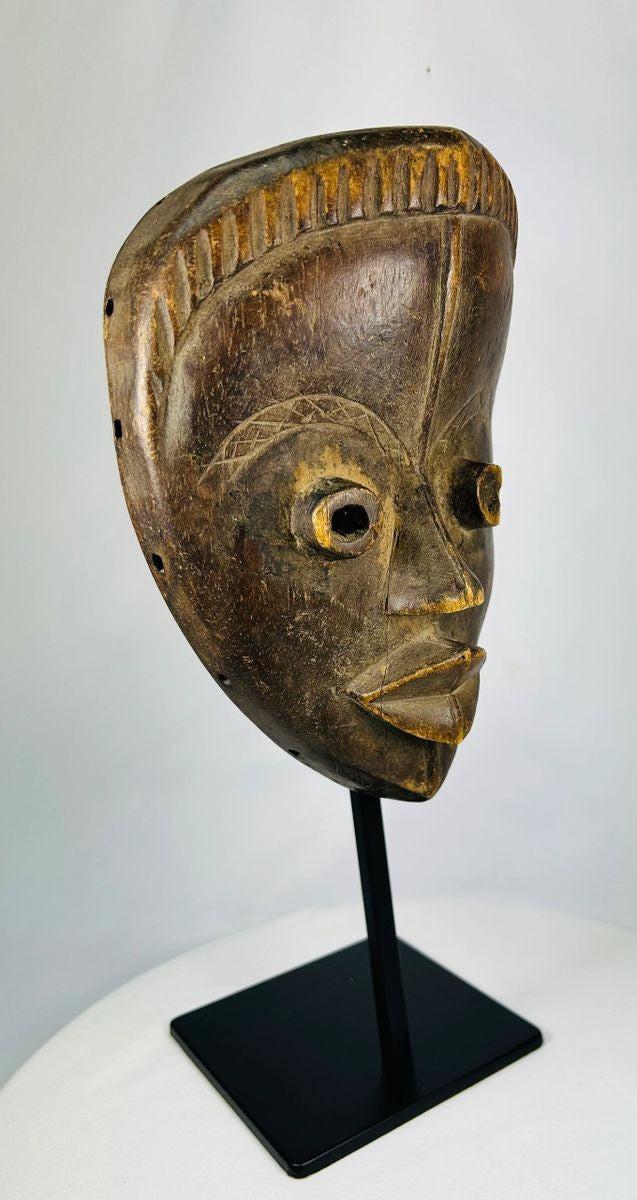 Authentic Baule hardwood mask showing traditional carving techniques and ritual wear