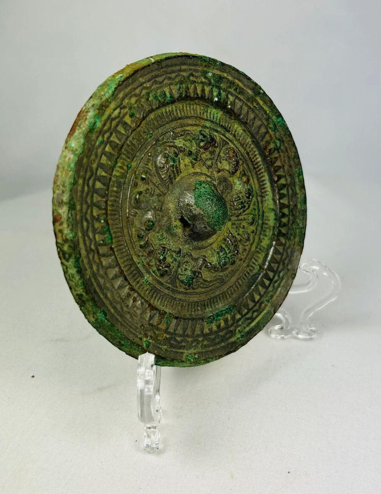 Ancient Chinese bronze mirror from the Han Dynasty featuring detailed patterns and a well-developed green patina.