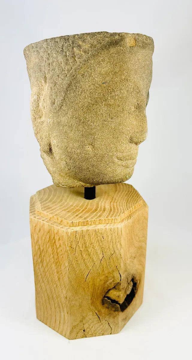 Right-side angled view of Khmer Sandstone Buddha Head Fragment from 12th-Century Angkor Period Cambodia, showing serene facial features and detailed carving on sandstone, mounted on wooden base – Relic and Rarity.