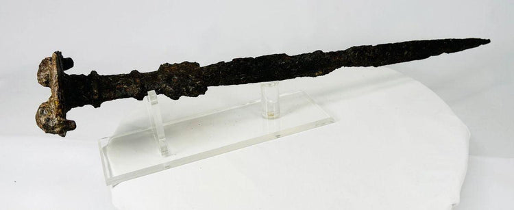 Luristan iron short sword, circa 750–650 BCE, from Western Iran. Ancient Near Eastern Iron Age weapon featuring lion-head disc pommel, ribbed grip, and straight double-edged blade. Displays aged patina and surface oxidization from burial, highlighting Luristan craftsmanship and martial artistry.