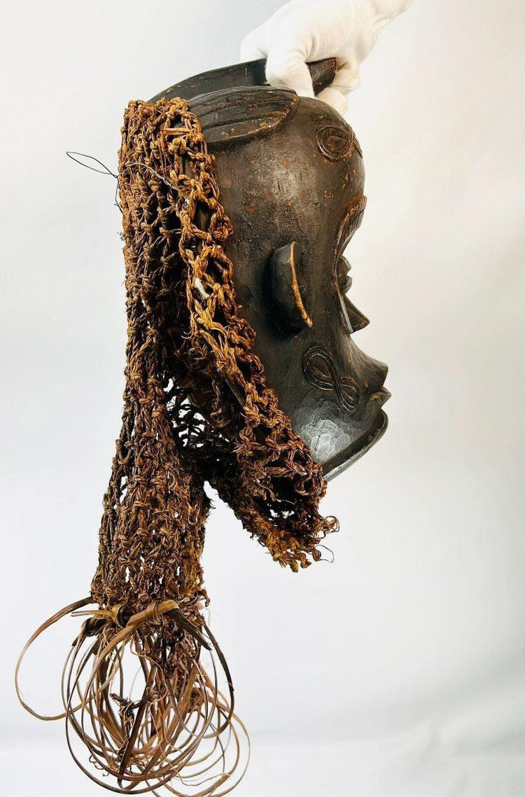 Central African Chokwe wooden mask featuring wickerwork fiber adornments